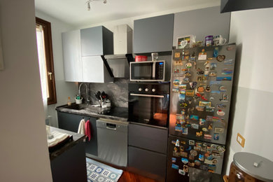 Foto de cocinas en L moderna pequeña cerrada sin isla con fregadero integrado, armarios con paneles lisos, encimera de laminado y electrodomésticos de acero inoxidable