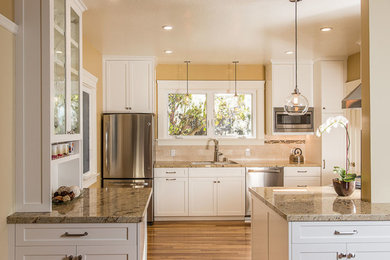 Mid-sized transitional u-shaped medium tone wood floor eat-in kitchen photo in San Francisco with a double-bowl sink, shaker cabinets, white cabinets, beige backsplash, stainless steel appliances, granite countertops, matchstick tile backsplash and a peninsula