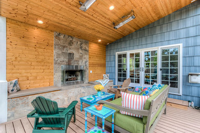 Large arts and crafts backyard deck photo in Seattle with a fire pit and a roof extension