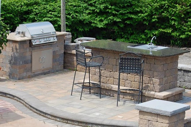 This is an example of a mid-sized traditional backyard patio in San Francisco with an outdoor kitchen, brick pavers and no cover.