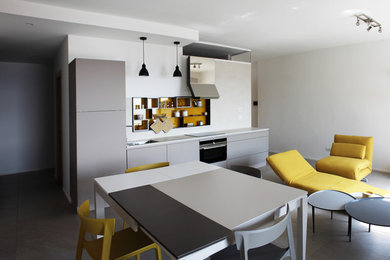 Immagine di un piccolo soggiorno design aperto con angolo bar, pareti bianche, pavimento in gres porcellanato, TV a parete e pavimento grigio