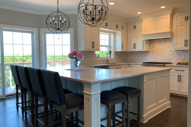 Inspiration for an u-shaped eat-in kitchen in Milwaukee with an undermount sink, recessed-panel cabinets, white cabinets, quartzite benchtops, multi-coloured splashback, stainless steel appliances, dark hardwood floors, brown floor and white benchtop.