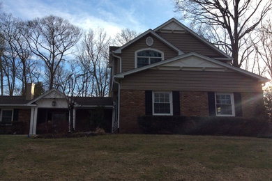 Inspiration for a large timeless beige split-level concrete fiberboard house exterior remodel in New York with a hip roof and a shingle roof