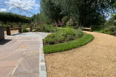 This is an example of a large traditional side yard patio with natural stone pavers and an awning.