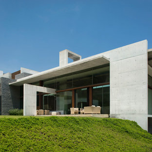 Bild på ett funkis grått hus, med platt tak