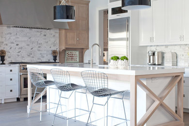 Inspiration for a large transitional l-shaped light wood floor eat-in kitchen remodel in Chicago with an undermount sink, shaker cabinets, white cabinets, quartzite countertops, gray backsplash, stone tile backsplash, stainless steel appliances and an island