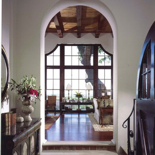 Foto di un ingresso con vestibolo mediterraneo con pareti bianche e pavimento in mattoni