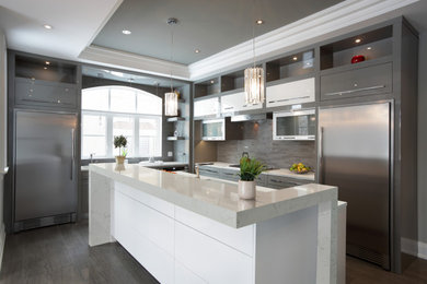 Inredning av ett modernt mellanstort grå grått kök, med släta luckor, grå skåp, bänkskiva i kvarts, flerfärgad stänkskydd, rostfria vitvaror, klinkergolv i porslin, en köksö och grått golv