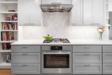 Large trendy l-shaped light wood floor eat-in kitchen photo in Other with a double-bowl sink, shaker cabinets, white cabinets, quartz countertops, white backsplash, mosaic tile backsplash, stainless steel appliances and an island