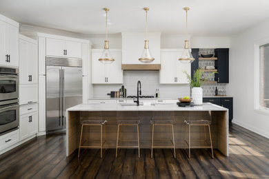 Mid-sized trendy u-shaped dark wood floor eat-in kitchen photo in Indianapolis with an undermount sink, shaker cabinets, white cabinets, quartz countertops, white backsplash, stainless steel appliances, an island and white countertops