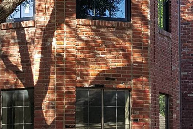 Photo of a large traditional two-storey brick red exterior in Dallas with a gable roof.