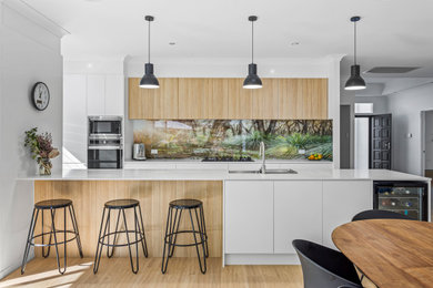 Inspiration for a large contemporary galley eat-in kitchen in Gold Coast - Tweed with an undermount sink, recessed-panel cabinets, quartz benchtops, multi-coloured splashback, glass sheet splashback, stainless steel appliances and white benchtop.