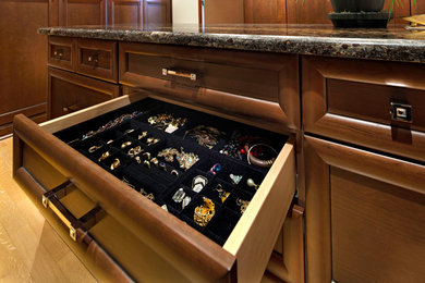 Inspiration for a large timeless women's light wood floor dressing room remodel in Jacksonville with recessed-panel cabinets and dark wood cabinets