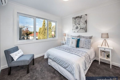 This is an example of a mid-sized contemporary master bedroom in Melbourne with white walls and carpet.