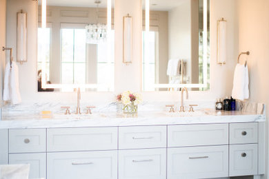 This is an example of a mid-sized contemporary master bathroom in Denver with white cabinets, a freestanding tub, beige walls, ceramic floors, multi-coloured floor, white benchtops, marble benchtops, a double vanity, a built-in vanity, shaker cabinets, an alcove shower, an undermount sink and a hinged shower door.