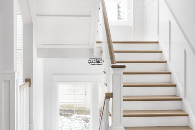 Staircase - cottage wooden u-shaped wood railing and wainscoting staircase idea in Chicago with painted risers