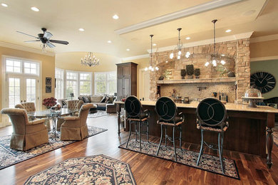 Example of a mid-sized classic single-wall medium tone wood floor open concept kitchen design in Chicago with an island, a farmhouse sink, raised-panel cabinets, dark wood cabinets, granite countertops and stainless steel appliances
