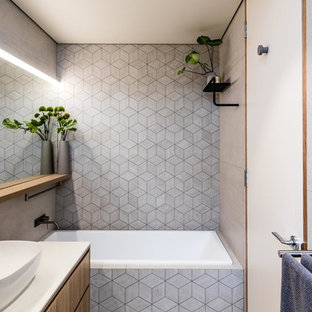 Ispirazione per una stanza da bagno minimalista con ante lisce, ante in legno scuro, vasca da incasso, piastrelle di cemento, pareti grigie, pavimento in cementine, lavabo a bacinella, pavimento grigio e top bianco