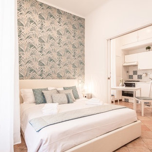 Réalisation d'une petite chambre parentale méditerranéenne avec un mur blanc, un sol en carreau de terre cuite et un sol rouge.