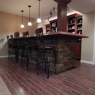 This is an example of a medium sized rustic fully buried basement in Detroit with beige walls, dark hardwood flooring, no fireplace and red floors.