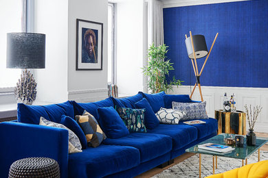 Photo of a mid-sized contemporary formal open concept living room in Barcelona with blue walls, light hardwood floors, no fireplace and beige floor.
