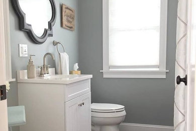 Bathroom - mid-sized transitional 3/4 dark wood floor and brown floor bathroom idea in Bridgeport with recessed-panel cabinets, white cabinets, gray walls, an undermount sink and solid surface countertops