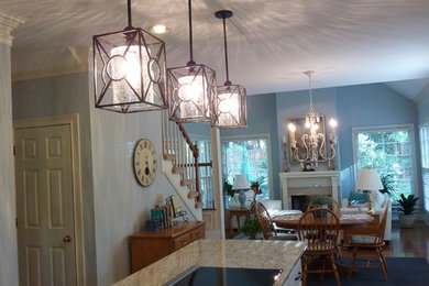Eat-in kitchen - mid-sized traditional l-shaped medium tone wood floor and brown floor eat-in kitchen idea in Nashville with raised-panel cabinets, brown cabinets, granite countertops, beige backsplash, glass tile backsplash, an island, an undermount sink and stainless steel appliances