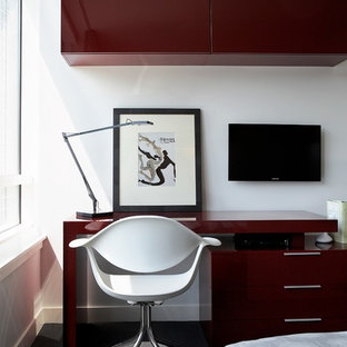 This is an example of a modern home office and library in Chicago with white walls, carpet and a freestanding desk.