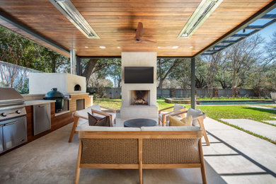 Huge minimalist backyard concrete patio kitchen photo in Dallas with a gazebo