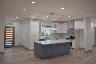Eat-in kitchen - mid-sized transitional u-shaped vinyl floor and gray floor eat-in kitchen idea in Sacramento with an undermount sink, recessed-panel cabinets, white cabinets, quartz countertops, white backsplash, marble backsplash, stainless steel appliances, an island and white countertops