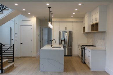 Trendy single-wall light wood floor and beige floor kitchen photo in Vancouver with an undermount sink, flat-panel cabinets, white cabinets, quartzite countertops, white backsplash and white countertops