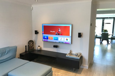 Photo of a medium sized modern formal open plan living room in Oxfordshire with white walls, vinyl flooring, no fireplace, a wall mounted tv and grey floors.