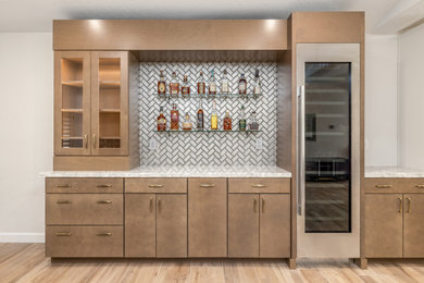Example of a large minimalist single-wall dry bar design in Phoenix with flat-panel cabinets, medium tone wood cabinets, quartz countertops, gray backsplash, glass tile backsplash and white countertops
