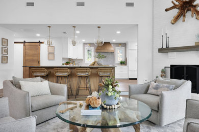 Inspiration for a large coastal l-shaped open concept kitchen remodel in Jacksonville with a farmhouse sink, recessed-panel cabinets, white cabinets, quartzite countertops, gray backsplash, ceramic backsplash, stainless steel appliances, an island and white countertops