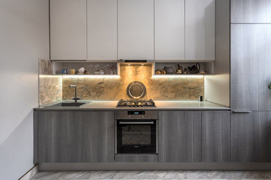 Small contemporary single-wall separate kitchen in Moscow with a drop-in sink, flat-panel cabinets, grey cabinets, quartz benchtops, stone tile splashback, stainless steel appliances, marble floors, no island and white floor.