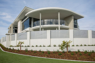 Inspiration for a tropical two-storey white exterior in Perth with stone veneer.