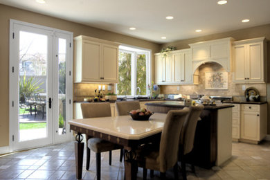 Example of a mid-sized transitional l-shaped cement tile floor eat-in kitchen design in Orange County with a double-bowl sink, recessed-panel cabinets, beige cabinets, granite countertops, multicolored backsplash, stone slab backsplash, stainless steel appliances and an island