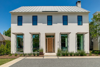 Example of a transitional beige two-story house exterior design in Dallas with a hip roof and a metal roof