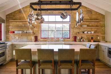 Cottage u-shaped medium tone wood floor kitchen photo in Santa Barbara with a farmhouse sink, shaker cabinets, gray cabinets, stainless steel appliances and an island