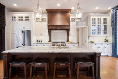 Eat-in kitchen - large coastal u-shaped medium tone wood floor and brown floor eat-in kitchen idea in Baltimore with an undermount sink, recessed-panel cabinets, white cabinets, quartz countertops, white backsplash, porcelain backsplash, stainless steel appliances, an island and multicolored countertops