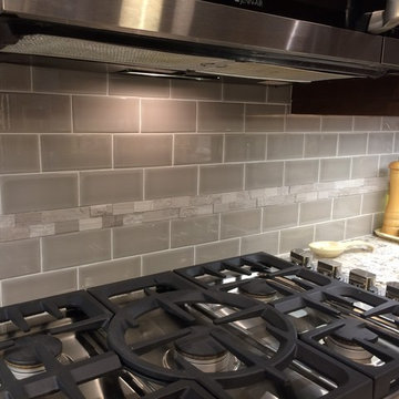 Light gray subway tile backsplash with a stone accent stripe