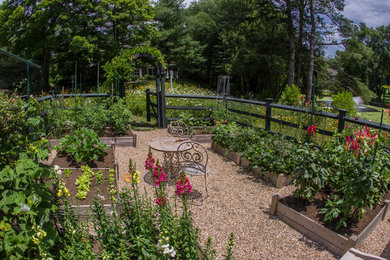 Photo of a large traditional backyard partial sun formal garden for summer in New York with a container garden and gravel.