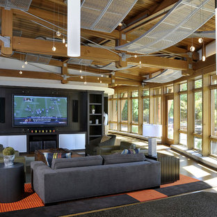 This is an example of a contemporary open plan home cinema in Grand Rapids with a wall mounted tv.