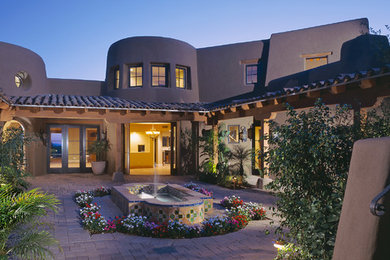 Design ideas for an expansive two-storey stucco beige house exterior in Phoenix with a flat roof and a tile roof.