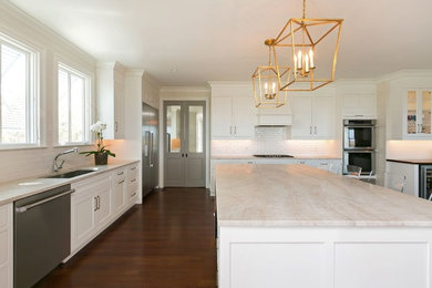 Photo of a modern l-shaped eat-in kitchen in Charleston with a double-bowl sink, flat-panel cabinets, white cabinets, quartzite benchtops, white splashback, porcelain splashback, stainless steel appliances, dark hardwood floors, with island and brown floor.