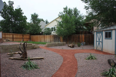 This is an example of a large traditional drought-tolerant and full sun backyard gravel landscaping in Denver.