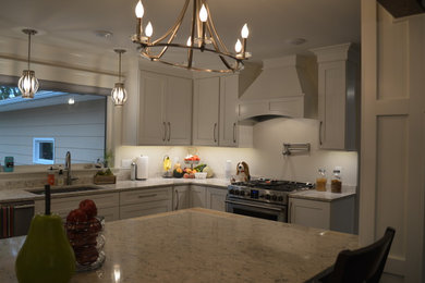 Eat-in kitchen - large traditional l-shaped vinyl floor eat-in kitchen idea in Other with an undermount sink, shaker cabinets, white cabinets, quartz countertops, stainless steel appliances and an island