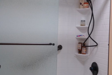 Example of a mid-sized classic master alcove shower design in San Francisco with white walls and a hinged shower door