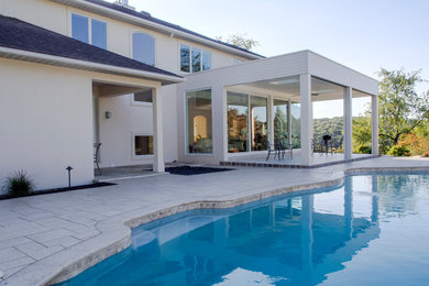 Inspiration for a mid-sized contemporary backyard concrete paver patio remodel in Philadelphia with a roof extension