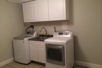 Inspiration for a mid-sized contemporary linoleum floor utility room remodel in Baltimore with a drop-in sink, recessed-panel cabinets, white cabinets, granite countertops, beige walls and a side-by-side washer/dryer